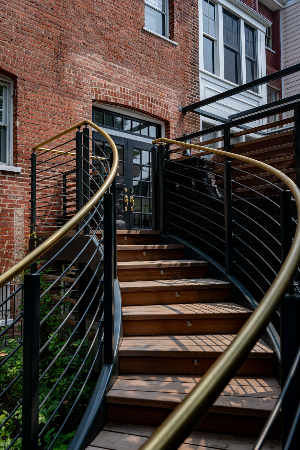 Curved exterior staircase with steel railings against a brick building